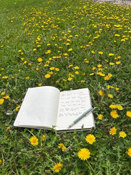 free-photo-of-open-notebook-on-green-grass-with-yellow-dandelions